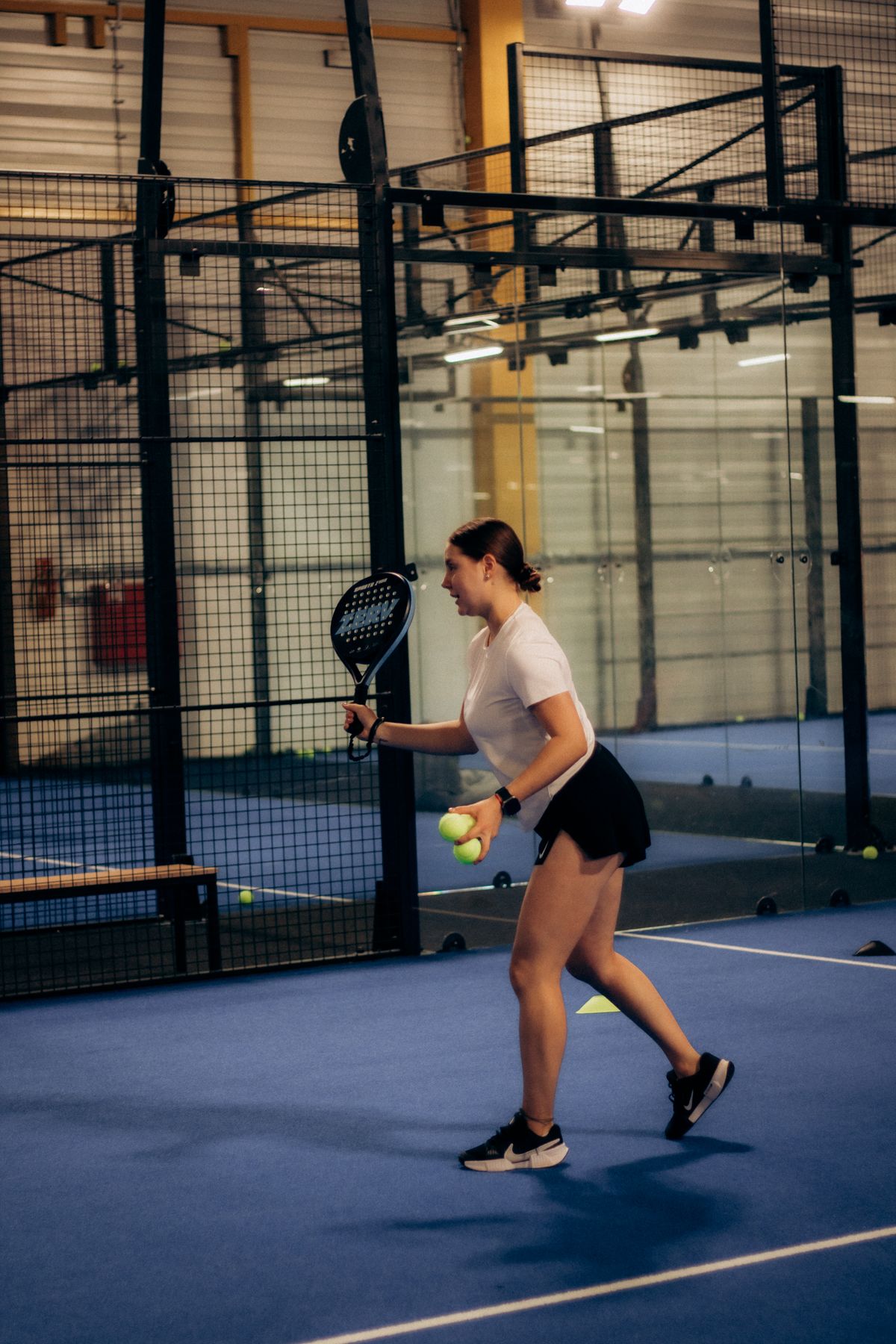 Padel player preparing to serve on an indoor court
