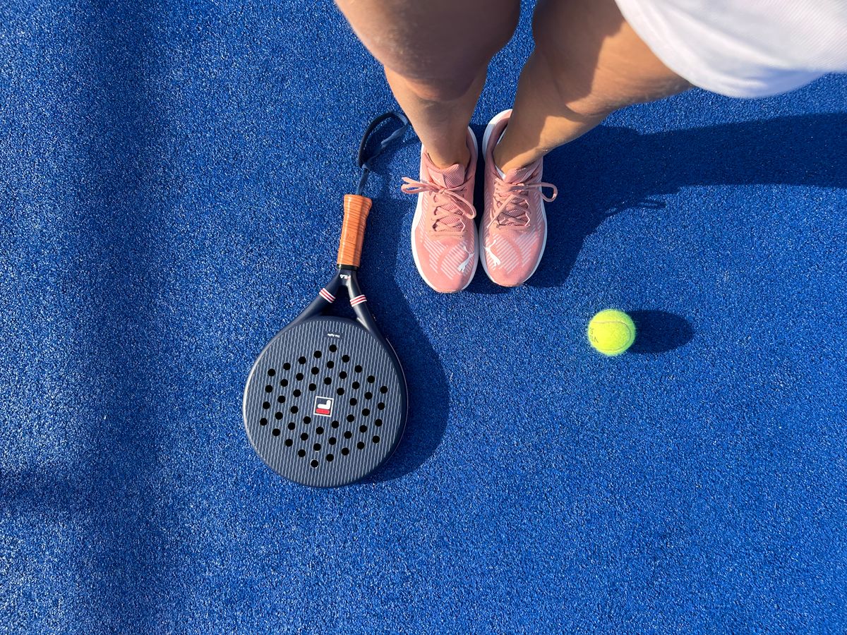Close-up of a padel racket and ball on court